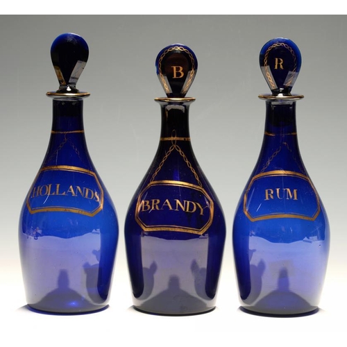 104 - THREE ENGLISH BLUE GLASS DECANTERS AND STOPPERS,  LATE 19TH C  labelled in gilt  BRANDY, HOLLANDS or... 