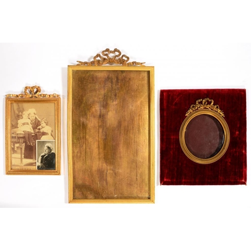 558 - THREE VICTORIAN GILT BRASS PHOTOGRAPH FRAMES, C1900   crested by a bow, 35 x 19cm and smaller ... 