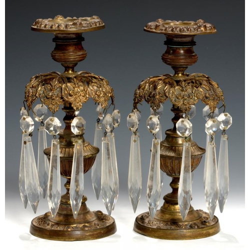 615 - A PAIR OF EARLY VICTORIAN EMBOSSED BRASS LUSTRE CANDLESTICKS, C1840 nozzles,  the foot iron weighted... 