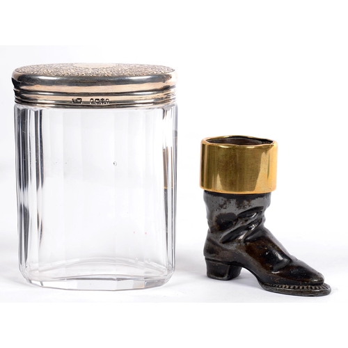 312 - A VICTORIAN BRASS MOUNTED LEAD BOOT NOVELTY MATCH STAND, 6CM H AND A GLASS JAR WITH SILVER COVER FRO... 