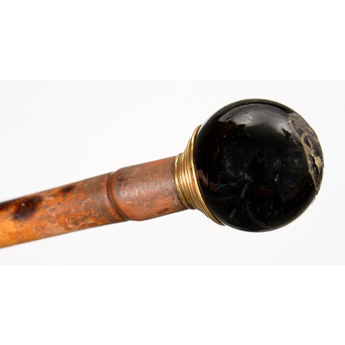 342 - A BAMBOO CANE WITH GLOBULAR GILTMETAL MOUNTED HARDSTONE POMMEL, 80CM L