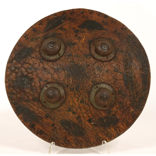 261 - AN INDIAN LEATHER SHIELD, DHAL, WITH FOUR IRON BOSSES, 24.5CM D, PROBABLY 19TH C