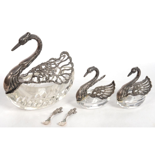 132 - A SET OF THREE SILVER MOUNTED GLASS SWAN SALT CELLARS AND TWO SPOONS, LARGEST 12 CM H, IMPORT MARKED... 