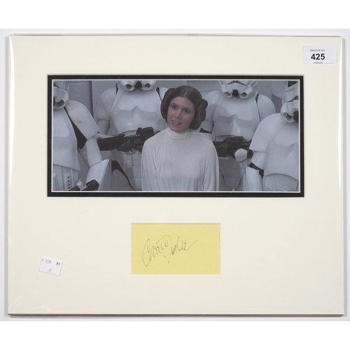 425 - STAR WARS INTEREST. CARRIE FISHER, PIECE SIGNED, MOUNTED WITH A PHOTOGRAPH, 32 X 39CM, UNFRAMED