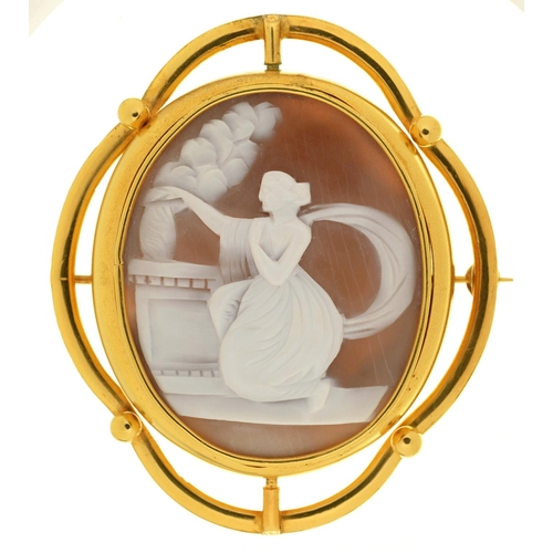 69 - A 19TH C CAMEO BROOCH, THE OVAL SHELL CARVED WITH A CLASSICAL WOMEN AT AN ALTAR, GILTMETAL MOUNT, 62... 