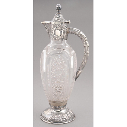 100 - A VICTORIAN SILVER MOUNTED CUT GLASS CLARET JUG on silver foot, engraved within a cartouche Presente... 