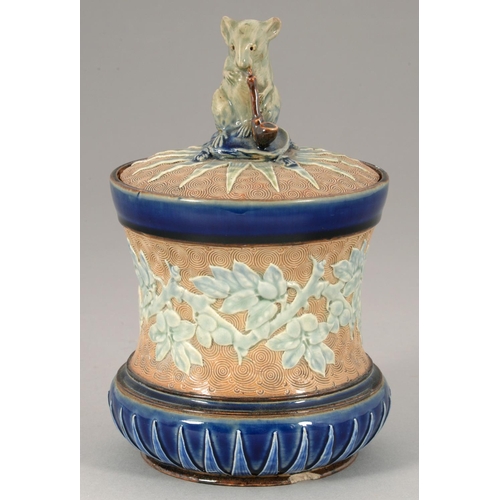 120 - ATTRIBUTED TO GEORGE TINWORTH.  A DOULTON WARE TOBACCO JAR AND COVER, 1900 of spool shape, the cover... 