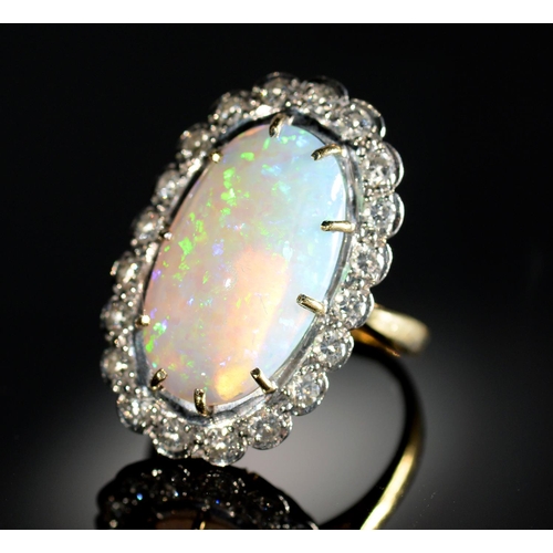 2 - AN OPAL AND DIAMOND RING  the 10 x 19mm oval opal of fine polish, in gold marked 18ct, 7.8g, size M... 