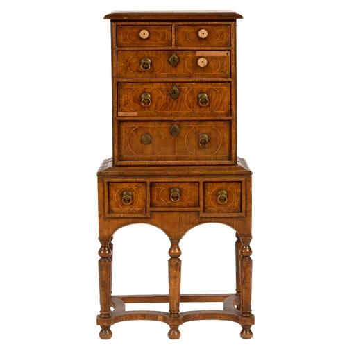 620 - A WALNUT AND GEOMETRIC INLAID CHEST ON STAND  incorporating earlier veneers,  the stand with incurve... 