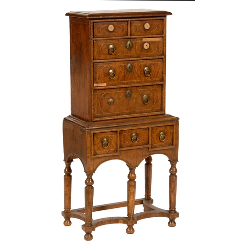 620 - A WALNUT AND GEOMETRIC INLAID CHEST ON STAND  incorporating earlier veneers,  the stand with incurve... 