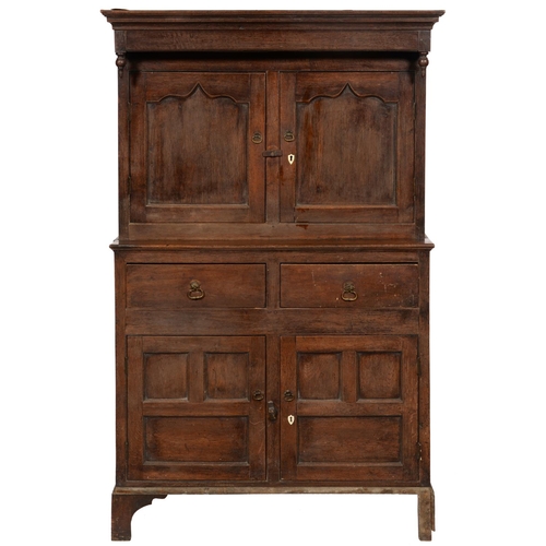 653 - AN OAK  PRESS CUPBOARD, 18TH C  the canopied upper part with turned pendants,  enclosed by twin ogee... 