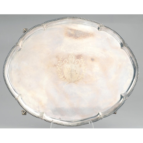 99 - A GEORGE III OVAL SILVER SALVER  engraved with contemporary armorials in shaped border and beaded ri... 