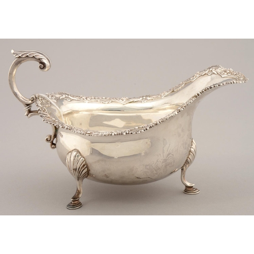 191 - AN EDWARD VII SILVER SAUCE BOAT, THE RIM APPLIED WITH SCALLOP SHELLS AND SCROLLING FOLIAGE, LEAF CAP... 