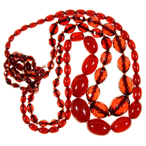 99 - A NECKLACE OF RED AMBER (FATURAN) BEADS AND A SIMILAR NECKLACE OF FACETED BEADS (2)