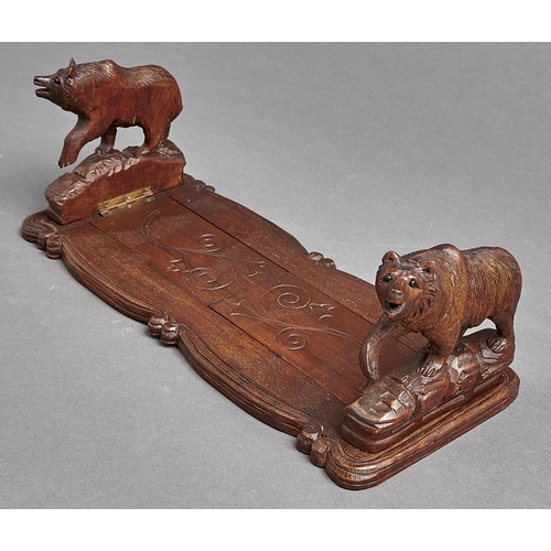 1081 - A Swiss carved and stained limewood book slide, the ends in the form of a bear, early 20th c, 34cm l... 