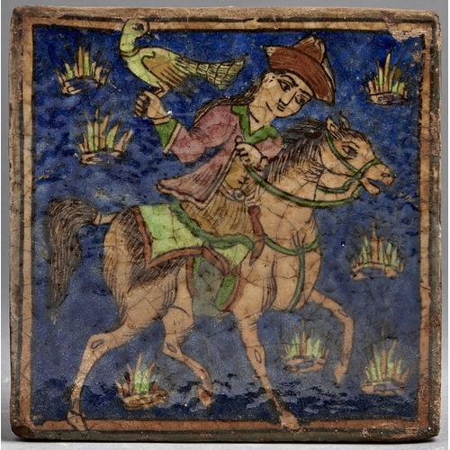 1085 - A Middle Eastern glazed tile, painted with a mounted falconer, 23.5 x 23.5cm