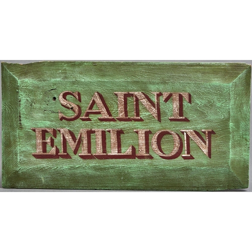 1127 - A decorative painted wood name board - Saint Emilion, 20th c, chamfered edges, 30 x 59cm... 