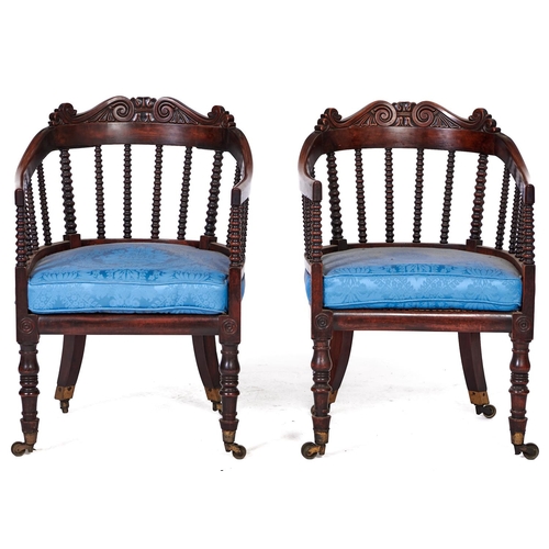 1552 - A pair of Victorian mahogany bergeres, c1850, the back hoop on bobbin turned spindles and crested by... 