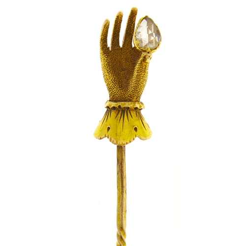 574 - A stick pin, 19th c, the gold terminal in the form of a lady's hand holding a pear shaped diamond be... 