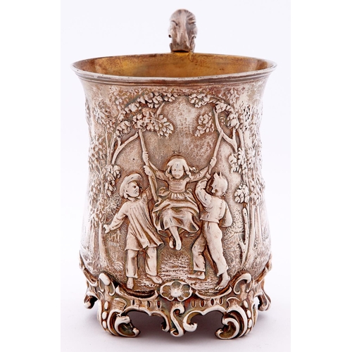 674 - A Victorian silver christening mug, of baluster form, embossed with three children playing on a swin... 