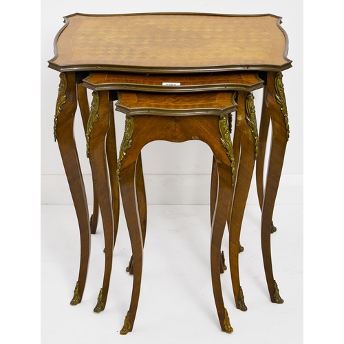 1543 - A nest of three kingwood and mahogany tables, 20th c, in Louis XV style, with cube parquetry top and... 