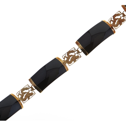 137 - A South East Asian gold and black onyx bracelet, with pierced and engraved dragon panels, marked 14k... 