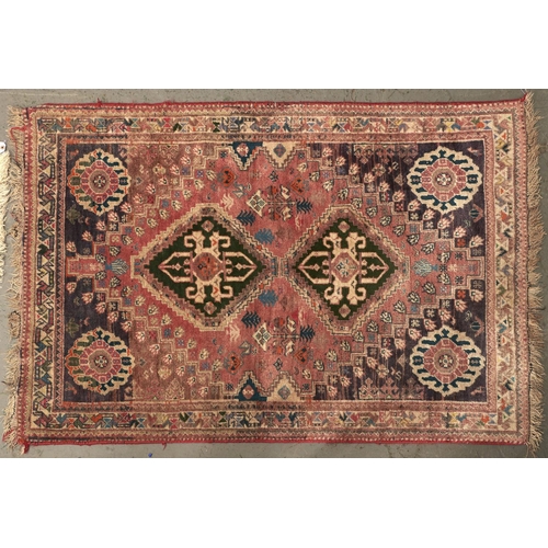 1450 - A modern Caucasian multicoloured bordered rug, the salmon pink field worked with two geometric medal... 