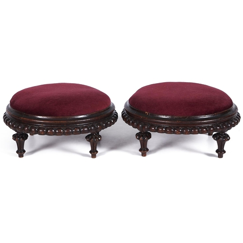 1555 - A pair of Victorian walnut circular footstools, c1870, with inset claret draylon tops with spreading... 