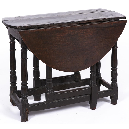 1564 - A oak gateleg table, late 17th c, the plank top with pair of folding D-shaped leaves on ring turned ... 