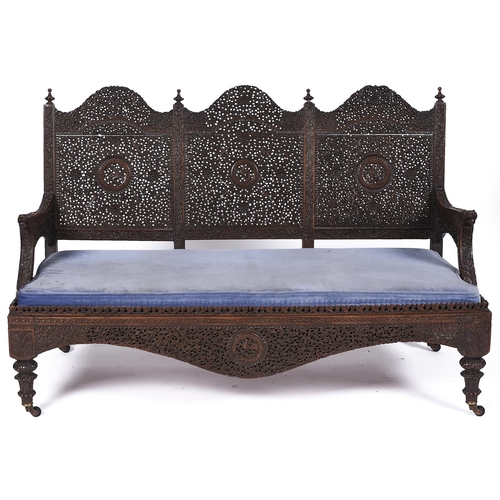 1569 - An Indian carved hardwood triple arch back sofa, late 19th c, finely pierced and carved with flowers... 