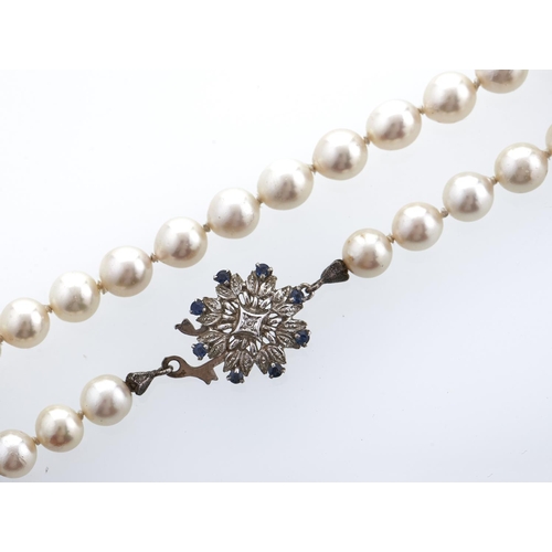 192 - A cultured pearl necklace with sapphire and diamond set white gold clasp, marked 750, 55.9g... 