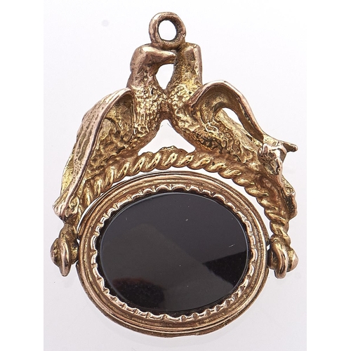 198 - An onyx set 9ct gold swivel fob seal, with billing doves mount, 8.5g