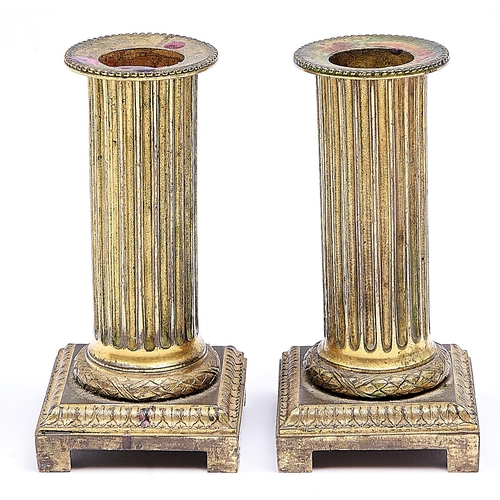 1151 - A pair of George III gilt bronze bracket candlesticks, c1820, columnar with beaded rim and laurels, ... 