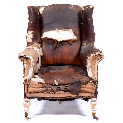 1324 - A leather upholstered wingback armchair, early 20th c, in George III style, earlier associated Victo... 