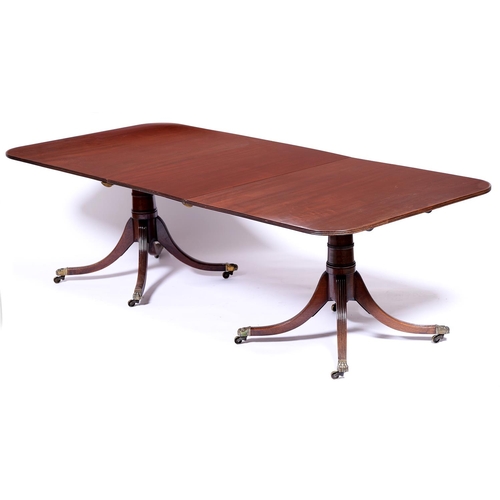 1334 - A Regency style mahogany twin pillar dining table, the figured top with reeded lip above tapered cyl... 