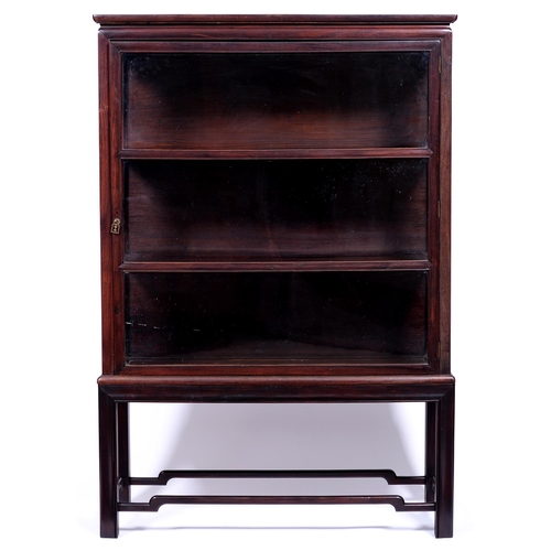 1345 - A Chinese hardwood cabinet,  second quarter 20th c,  fitted with shelves enclosed by a glazed door, ... 