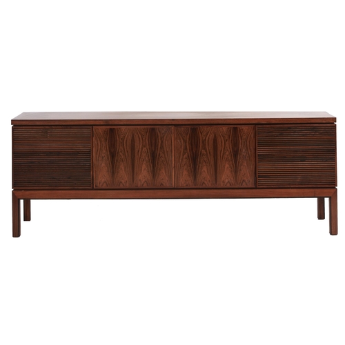 1355 - A rosewood sideboard, c1970,  fitted with drawer and cutlery tray, enclosed by plain or louvred... 