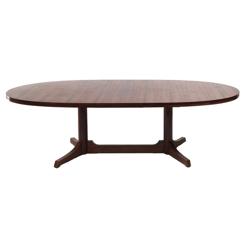 1356 - A rosewood dining table, c1970, the rounded top in matched veneers  on twin plain pillars with ... 