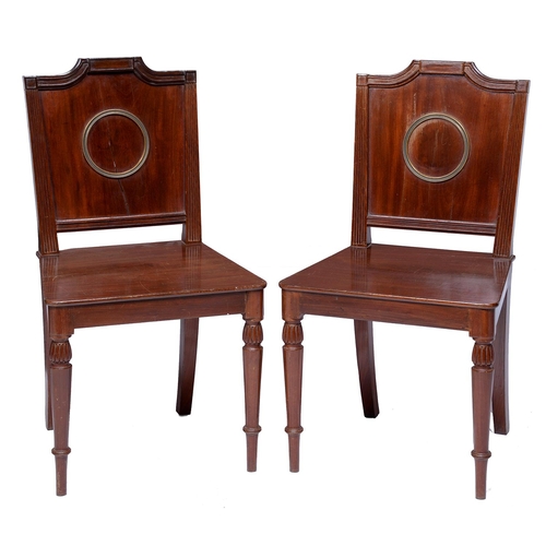 4 - A pair of Regency brass mounted mahogany hall chairs, the panel back applied with a brass ring benea... 