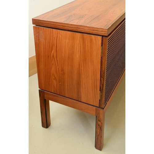 1355 - A rosewood sideboard, c1970,  fitted with drawer and cutlery tray, enclosed by plain or louvred... 