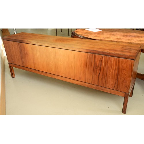 1355 - A rosewood sideboard, c1970,  fitted with drawer and cutlery tray, enclosed by plain or louvred... 