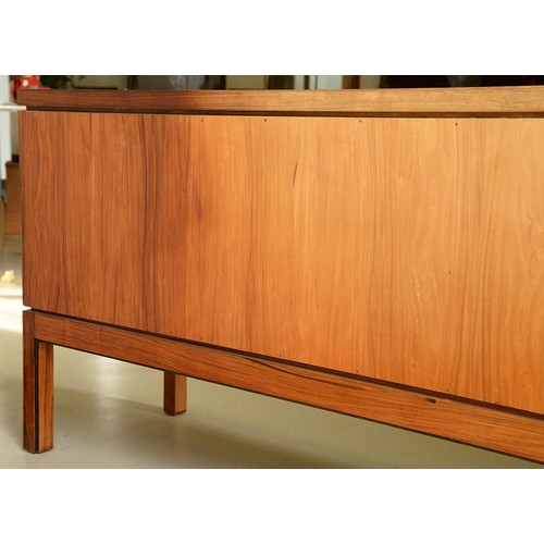 1355 - A rosewood sideboard, c1970,  fitted with drawer and cutlery tray, enclosed by plain or louvred... 