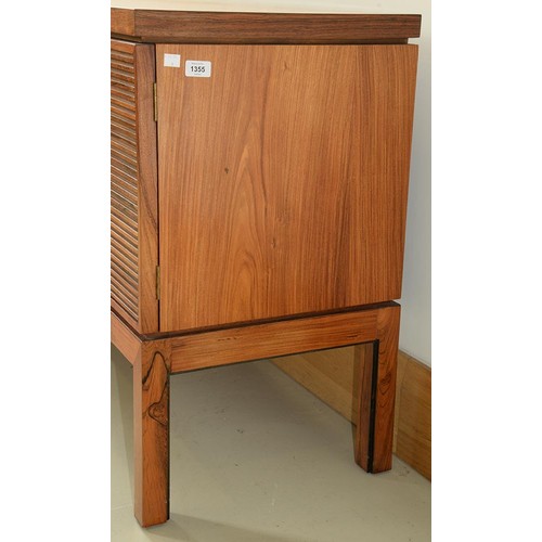 1355 - A rosewood sideboard, c1970,  fitted with drawer and cutlery tray, enclosed by plain or louvred... 