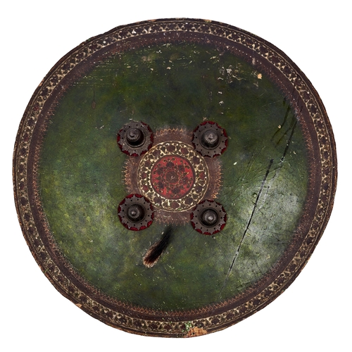 513 - An Indian lacquered hide shield, dhal, 19th c, of slightly convex form, the central red tooled round... 