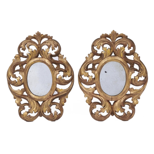 522 - A pair of Venetian miniature giltwood mirrors, 19th c, the oval plate surrounded by boldly scrolling... 