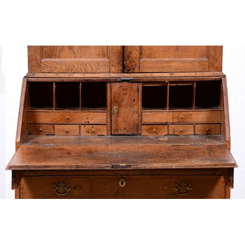 959 - A George III oak bureau-bookcase, the upper part with stepped cornice above twin panelled doors, the... 