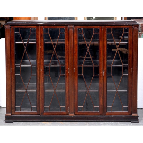 1386 - A mahogany bookcase, c1930, with bolection pediment and fitted with adjustable shelves enclosed by t... 