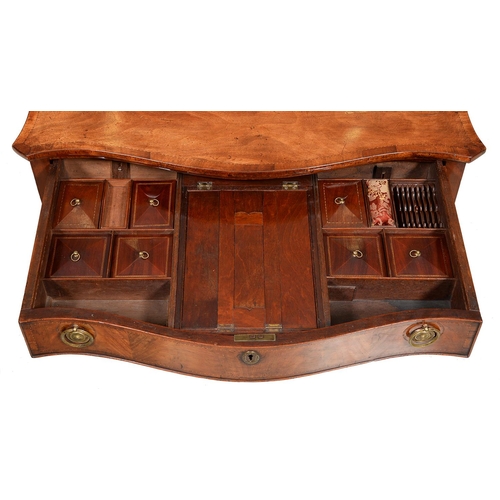 1246 - A George III serpentine mahogany dressing table, with broken line inlay and oval paterae, the drawer... 