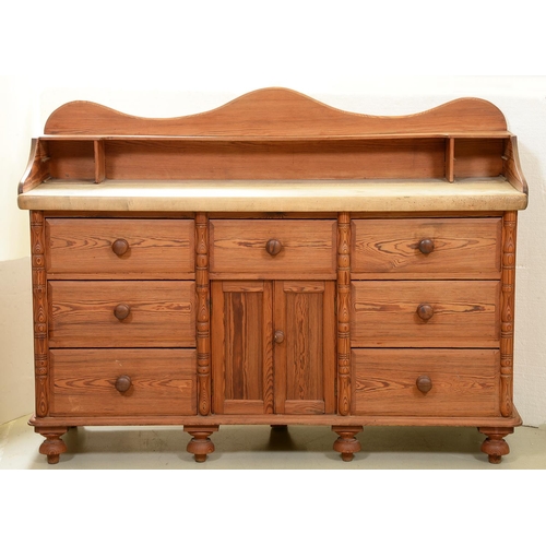 1254 - A Victorian pine dresser, with undulating upstand and scrubbed pine top, the front applied with spli... 