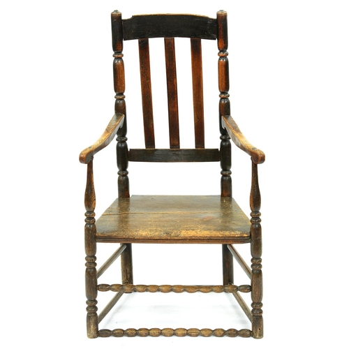 1354 - A George III elm armchair, with boarded seat and bobbin stretchers, seat height 37cm... 